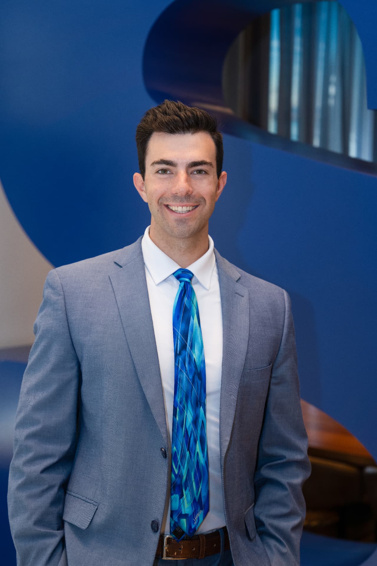 Matt Myles, REALTOR® with Myles Real Estate at SERHANT., in a grey suit and blue tie